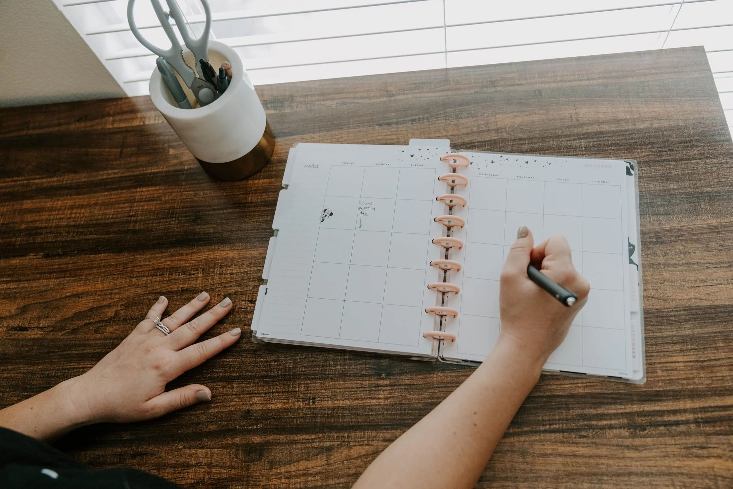 Hands writing on a calendar